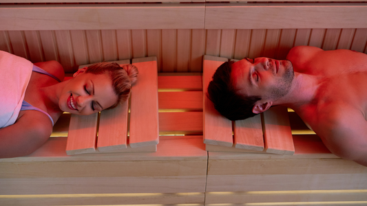 A Man And Woman Resting Comfortably In An Infrared Sauna