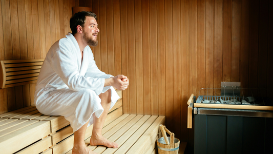 Man in a robe sitting in a sauna